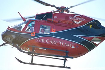 Photograph of a hovering helicopter with the words 'Air Care Team' on the side