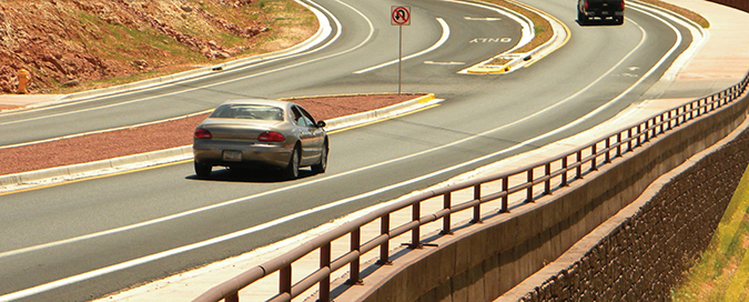 photo from the cover of the Noteworthy Practices Manual showing a car and a truck on a curved highway