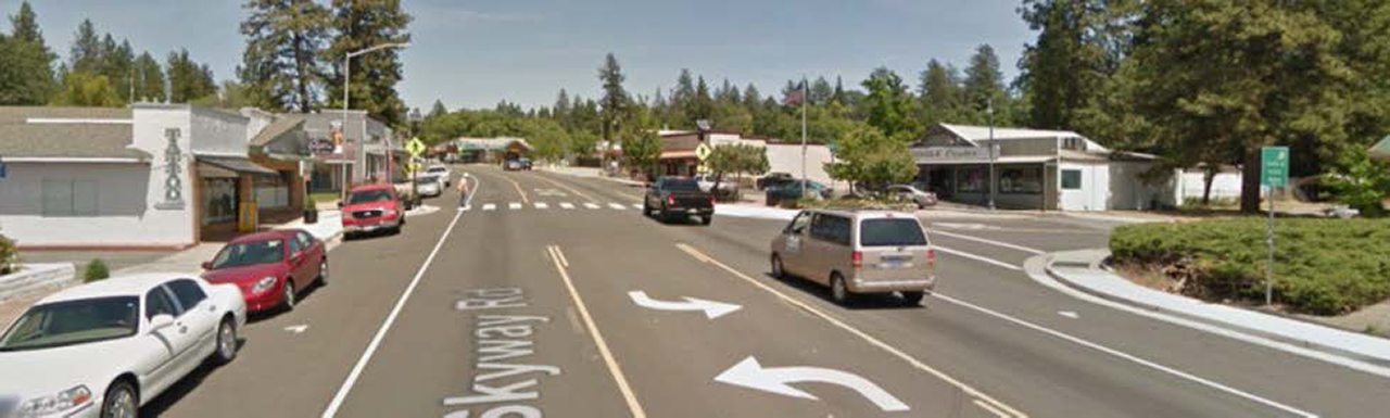 photo of Paradise Road after a configuration change: a roadway with one thru lane of traffic in each direction, a center two-away left turn lane, and parking lanes.