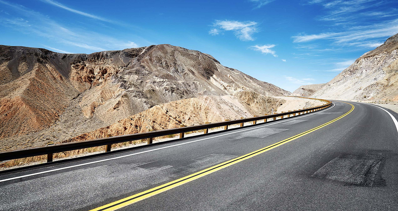 photo of a highway winding up in the mountains of a desert