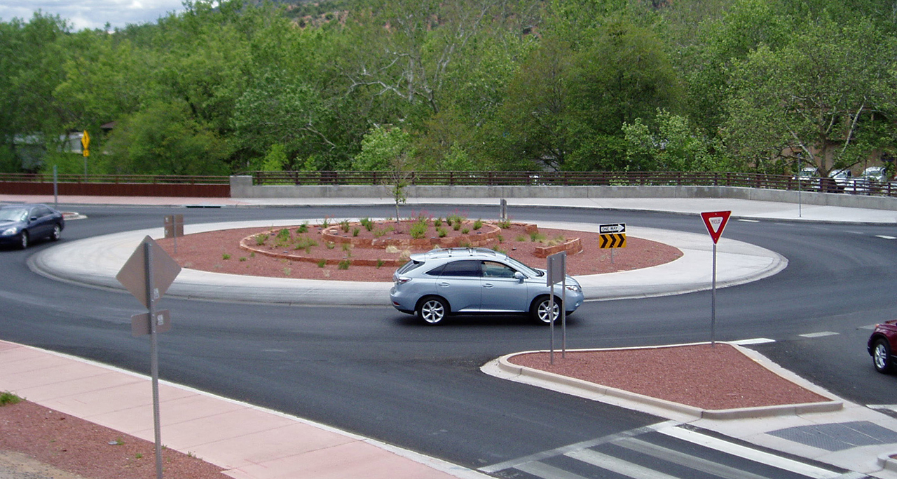 photo of two cars in a rotary and a third car waiting to enter