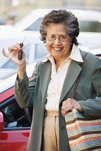 older woman smiling and holding up her car keys