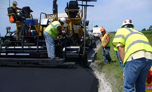 a road crew paving a road and employing a Safety Edge