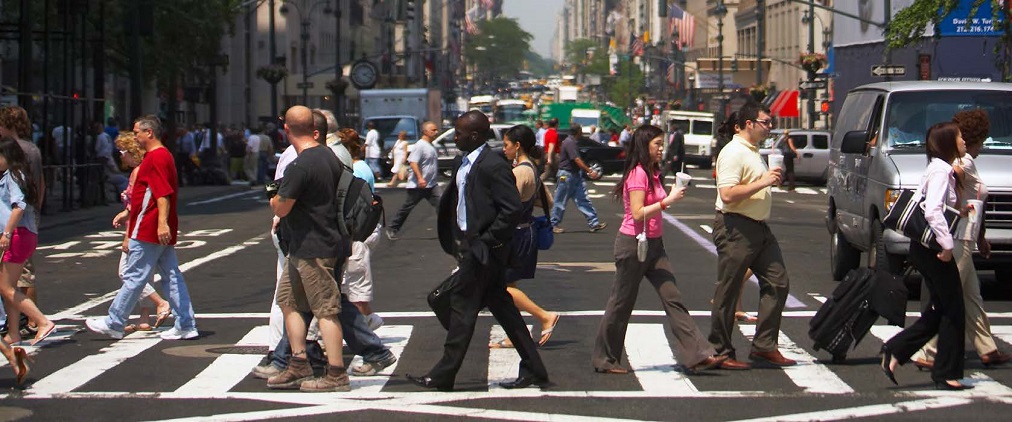a busy city crosswalk filled with pedestrians