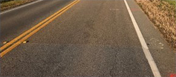 roadway with high friction pavement treatment