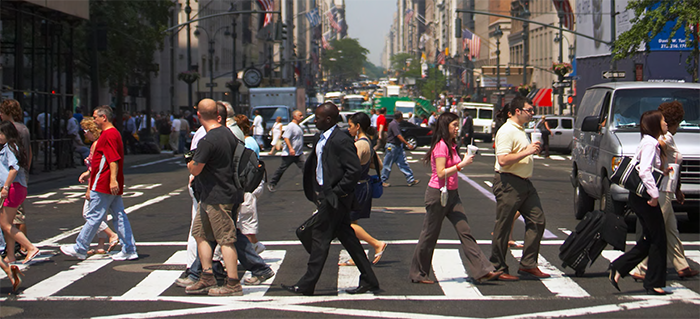 busy pedestrian crosswalk on a multi-lane, one-way city street