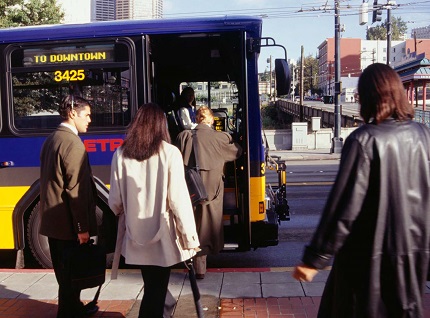 people getting on a transit bus at an urban street corner