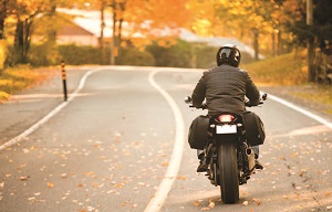a motorcyclist riding on a suburban street